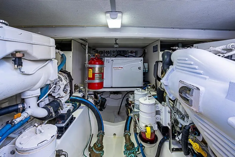 Slide: The Image of Engine room of 2013 Grand Banks 43 Europa yacht, featuring mechanical components and fire extinguisher. - 63