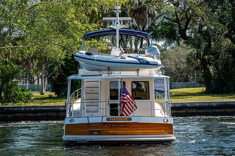 Slide: The Image of 2013 Grand Banks 43 Europa yacht with dinghy, cruising on a scenic waterway. - 7