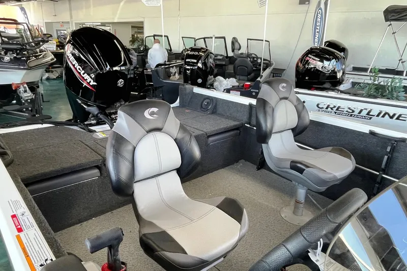 Slide: The Image of 2026 Crestliner 1650 Hawk boat interior with seating and Mercury engine. - 2