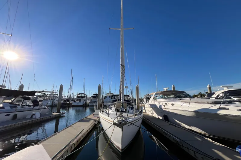 Slide: The Image of 1984 Catalina 36 MkII sailboat docked in a sunny marina, surrounded by other boats. - 2