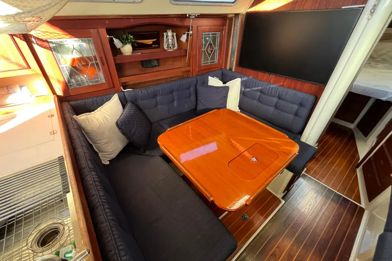 Slide: The Image of Cozy interior of 1984 Catalina 36 MkII sailboat with wooden table and cushioned seating. - 22