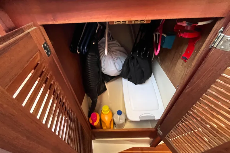 Slide: The Image of Wooden closet interior on 1984 Catalina 36 MkII, with hangers and cleaning supplies. - 34