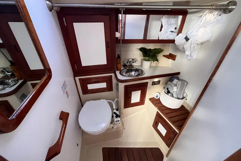 Slide: The Image of Compact bathroom in a 1984 Catalina 36 MkII sailboat, featuring wood accents and modern amenities. - 36