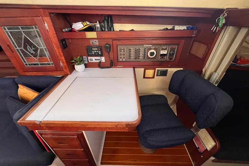 Slide: The Image of Navigation station inside a 1984 Catalina 36 MkII sailboat, featuring control panel and seating. - 39