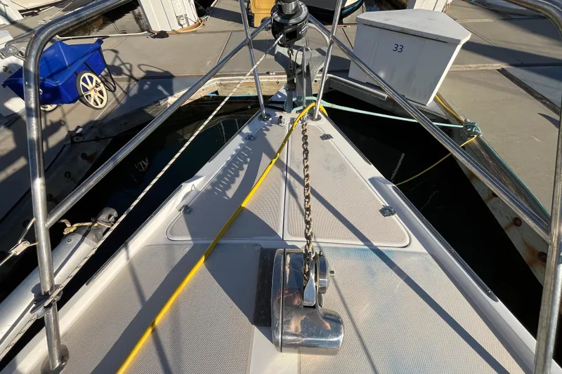 Slide: The Image of Bow of 1984 Catalina 36 MkII sailboat with anchor chain and dock view. - 6