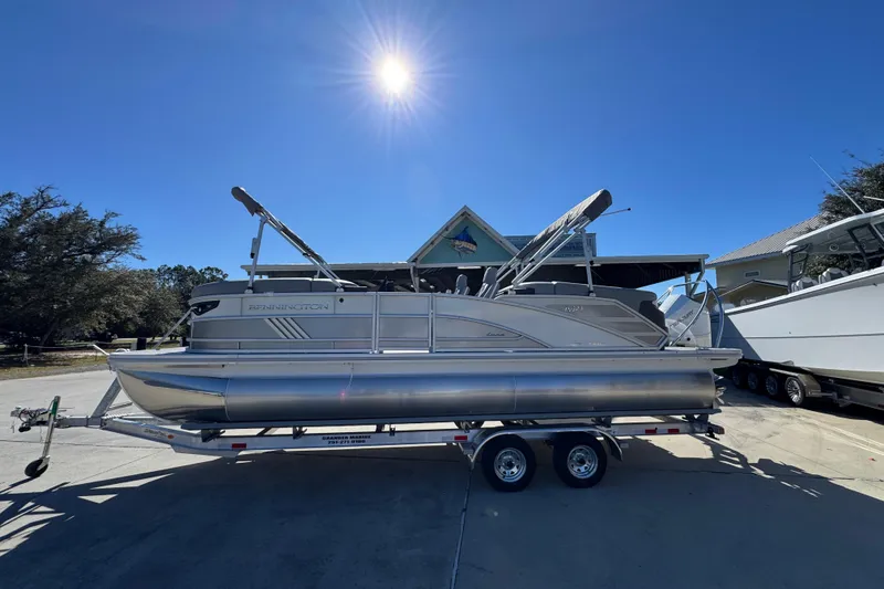 The Image of 2026 Bennington 23 MFB pontoon boat on trailer under bright sun. - 1