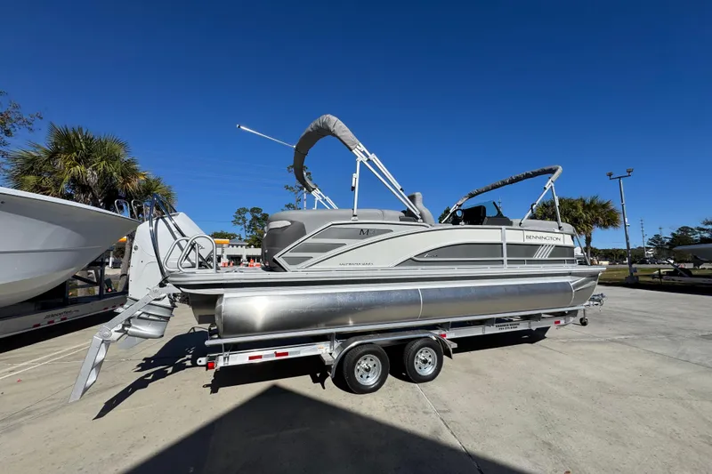 Slide: The Image of 2026 Bennington 23 MFB pontoon boat on trailer under clear blue sky. - 12