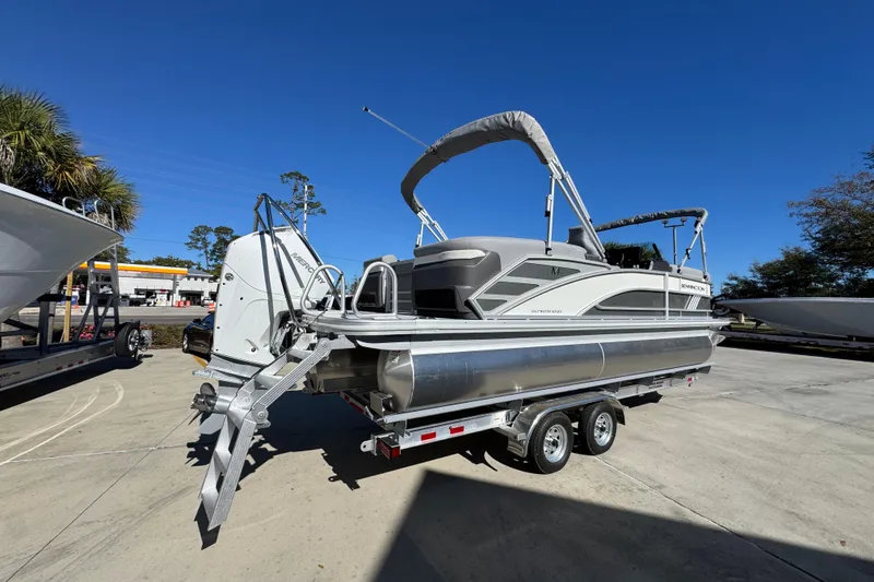 Slide: The Image of 2026 Bennington 23 MFB pontoon boat on trailer under clear blue sky. - 13