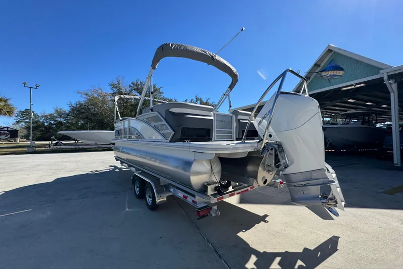 Slide: The Image of 2026 Bennington 23 MFB pontoon boat on trailer, parked outdoors under clear sky. - 17
