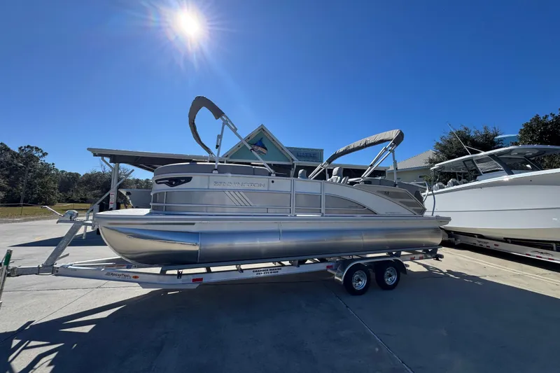 Slide: The Image of 2026 Bennington 23 MFB pontoon boat on trailer under clear blue sky. - 2