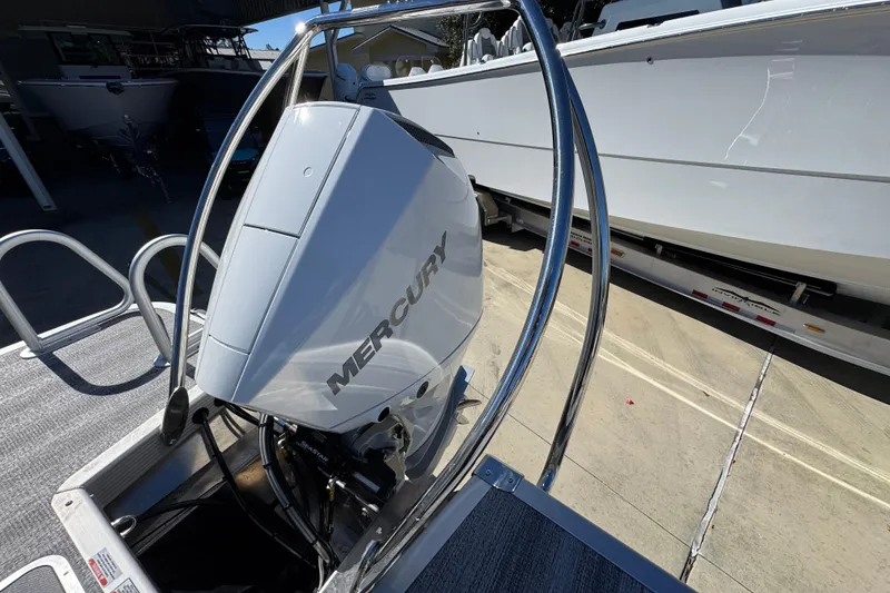 Slide: The Image of 2026 Bennington 23 MFB boat with Mercury outboard engine, docked in a marina. - 35