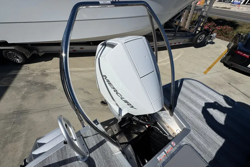 Slide: The Image of 2026 Bennington 23 MFB boat with Mercury outboard motor, parked on a trailer. - 36