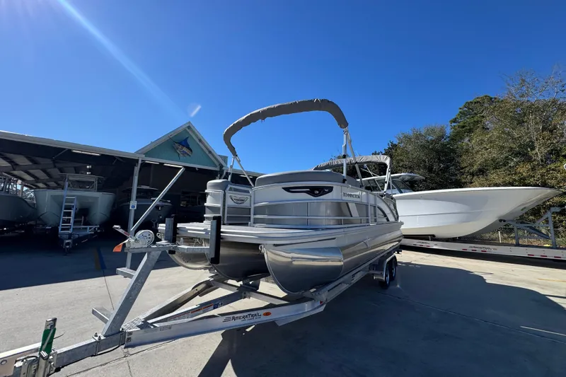 Slide: The Image of 2026 Bennington 23 MFB pontoon boat on trailer under clear blue sky. - 4