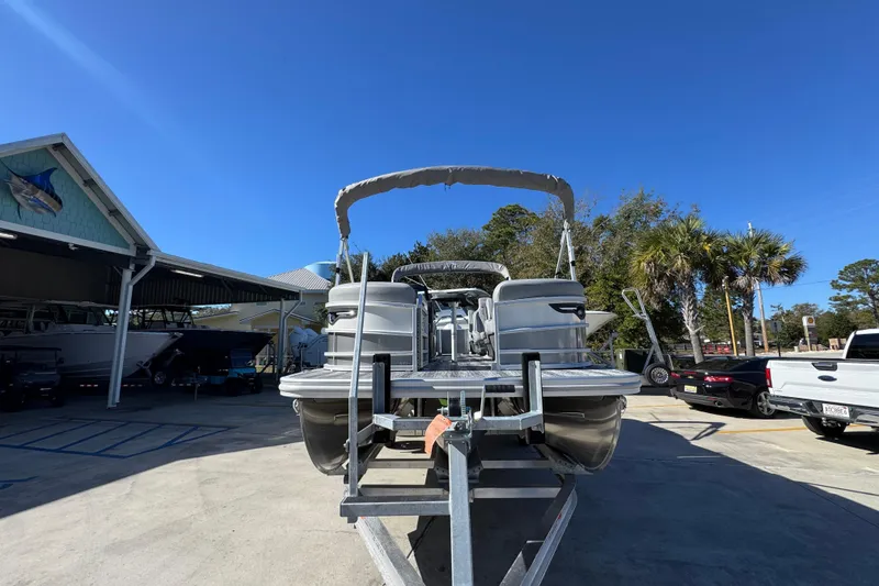 Slide: The Image of 2026 Bennington 23 MFB pontoon boat on trailer under clear blue sky. - 6