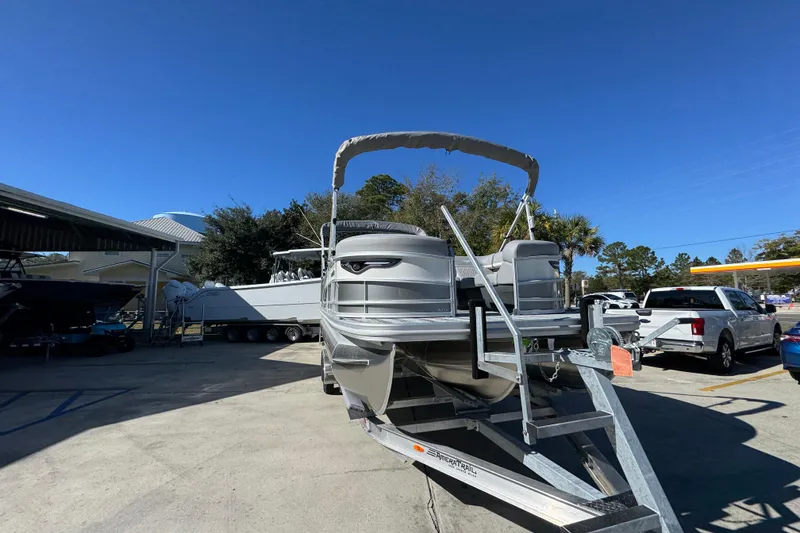 Slide: The Image of 2026 Bennington 23 MFB pontoon boat on trailer under clear blue sky. - 7