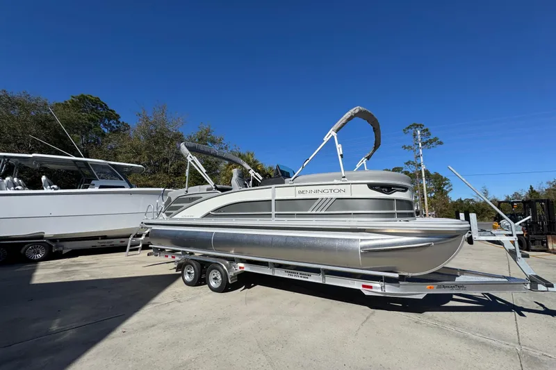 Slide: The Image of 2026 Bennington 23 MFB pontoon boat on trailer under clear blue sky. - 9