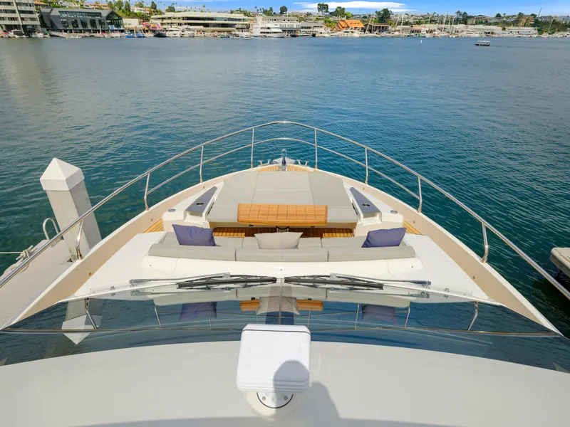 Slide: The Image of 2024 Absolute 60 Fly yacht bow with luxurious seating and scenic waterfront view. - 15