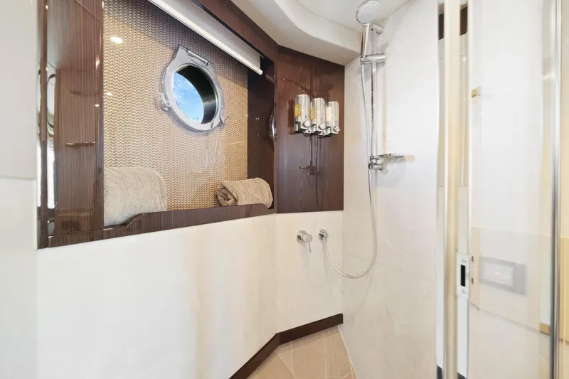 Slide: The Image of Luxurious bathroom on the 2024 Absolute 60 Fly yacht with modern fixtures and porthole. - 43