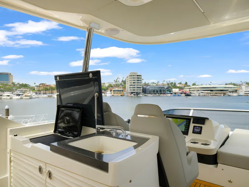 Slide: The Image of Flybridge of 2024 Absolute 60 Fly yacht with sink and seating, overlooking marina. - 19