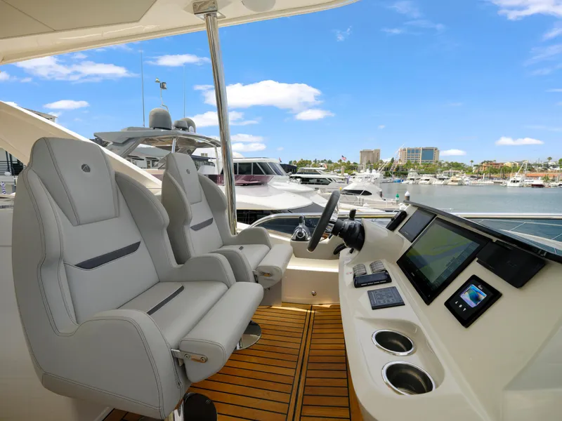 Slide: The Image of 2024 Absolute 60 Fly yacht helm station with dual seats and advanced navigation system. - 13