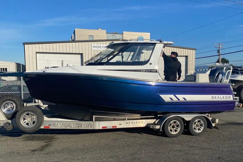 The Image of 2026 Sealegs 8.5m Cabin boat on trailer, parked outdoors. - 0