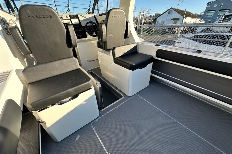 Slide: The Image of Interior of 2026 Sealegs 8.5m Cabin boat with black seats and steering console. - 16