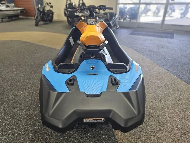 Slide: The Image of 2026 Sea-Doo Spark Trixx for 3, blue and orange, in a showroom. - 7