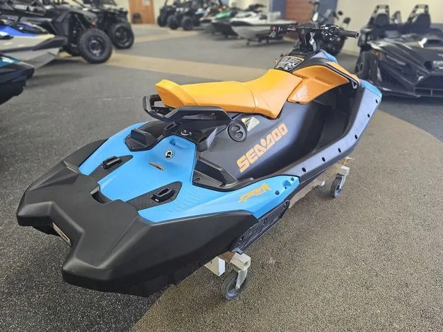 Slide: The Image of 2026 Sea-Doo Spark Trixx for 3, blue and orange, in a showroom. - 8