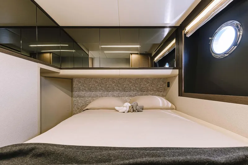 Slide: The Image of Luxurious bedroom interior of 2026 Absolute 52 FLY yacht with modern design and porthole window. - 25