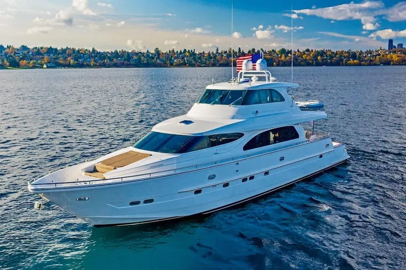 The Image of 2008 Horizon 82 Cockpit Motoryacht cruising on a scenic lake under a clear blue sky. - 0