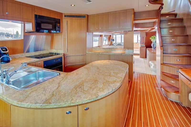 Slide: The Image of Luxurious kitchen interior of 2008 Horizon 82 Cockpit Motoryacht with wooden cabinetry and granite countertops. - 13
