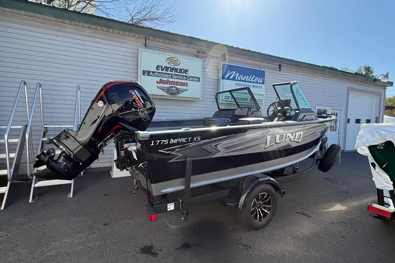 The Image of 2026 Lund 1775 Impact XS Sport boat displayed outside marine service center. - 0
