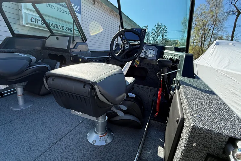 Slide: The Image of Interior of 2026 Lund 1775 Impact XS Sport boat with steering wheel and seating. - 7