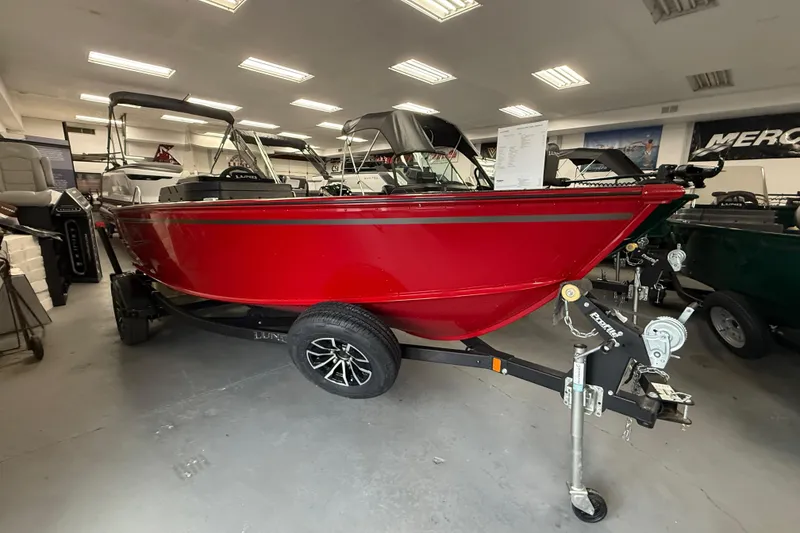 The Image of 2026 Lund 1700 Explorer SS boat in showroom, vibrant red color, on trailer. - 0