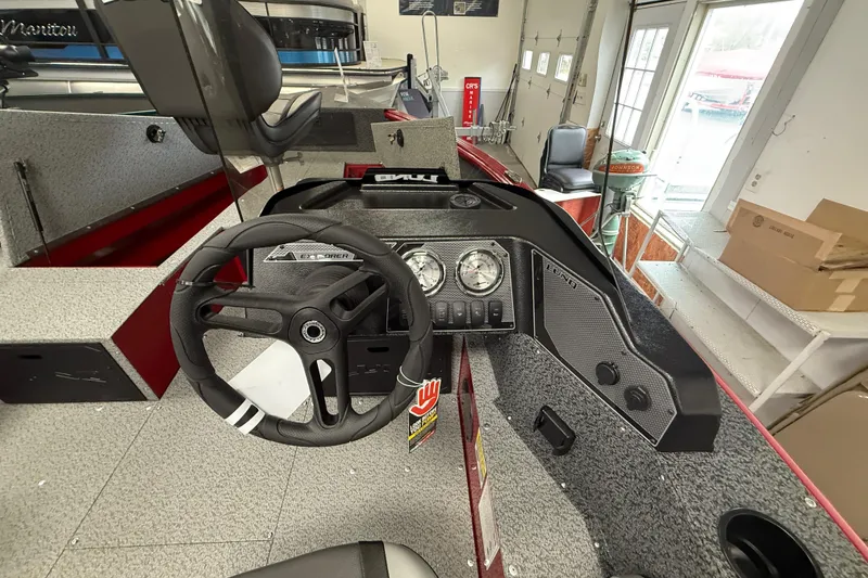 Slide: The Image of 2026 Lund 1700 Explorer SS boat interior with steering wheel and dashboard controls. - 13