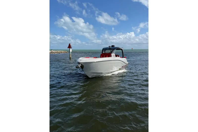 Slide: The Image of 2020 Deep Impact 399 Sport boat cruising on open water under a clear blue sky. - 3