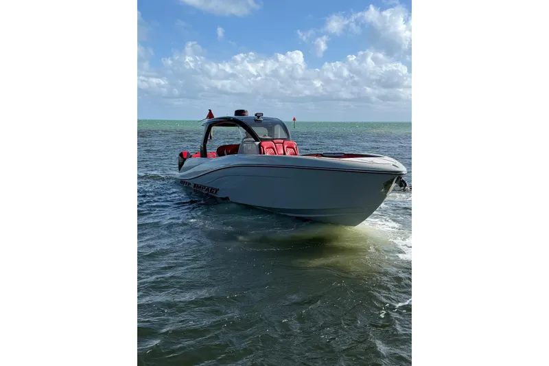 Slide: The Image of 2020 Deep Impact 399 Sport boat on water, featuring sleek design and red seating. - 4