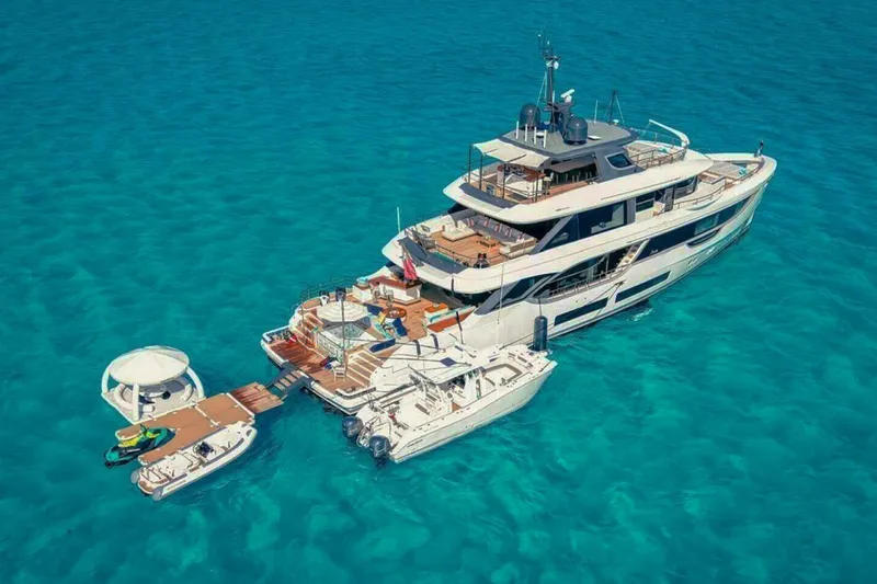 Slide: The Image of Luxurious 2023 Benetti Oasis 34M yacht on clear turquoise waters, featuring multiple decks and amenities. - 34