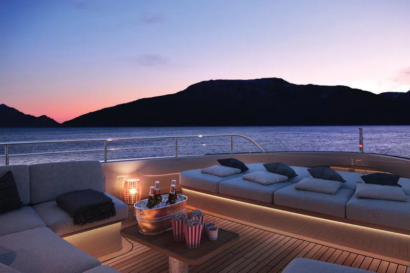 Slide: The Image of Luxurious 2023 Benetti Oasis 34M yacht deck at sunset, featuring elegant seating and refreshments. - 6
