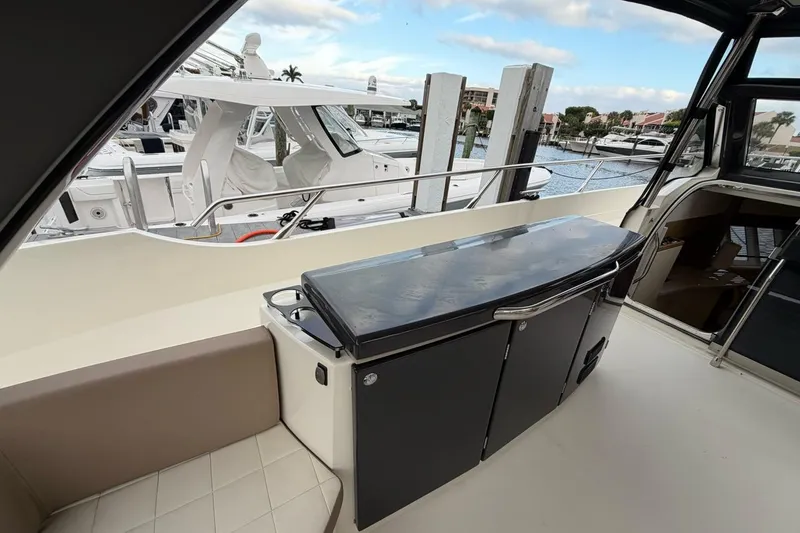 Slide: The Image of 2019 Absolute 40 SLT yacht with spacious sun deck, docked by serene waters. - 10