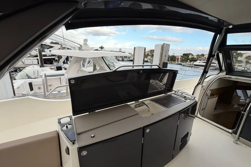 Slide: The Image of 2019 Absolute 40 SLT yacht with spacious sun deck, docked by serene waters. - 11