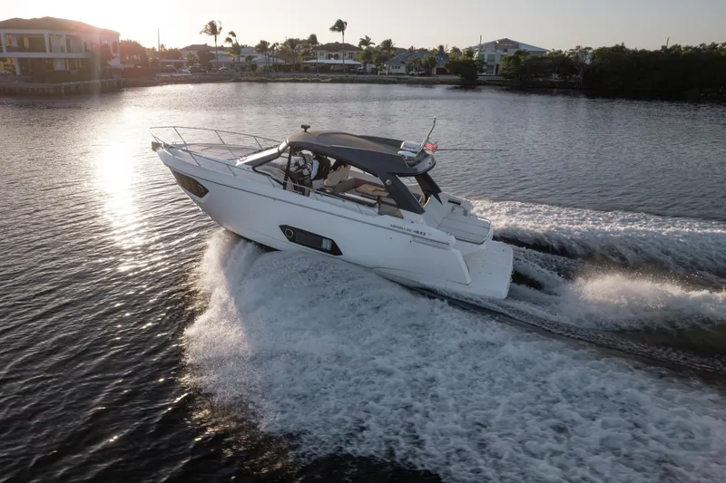 Slide: The Image of 2019 Absolute 40 SLT yacht cruising on a sunny day, creating waves in the water. - 40