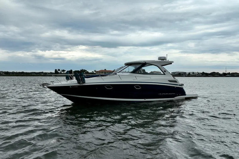 Slide: The Image of 2017 Regal 35 Sport Coupe on calm waters under cloudy sky. - 10
