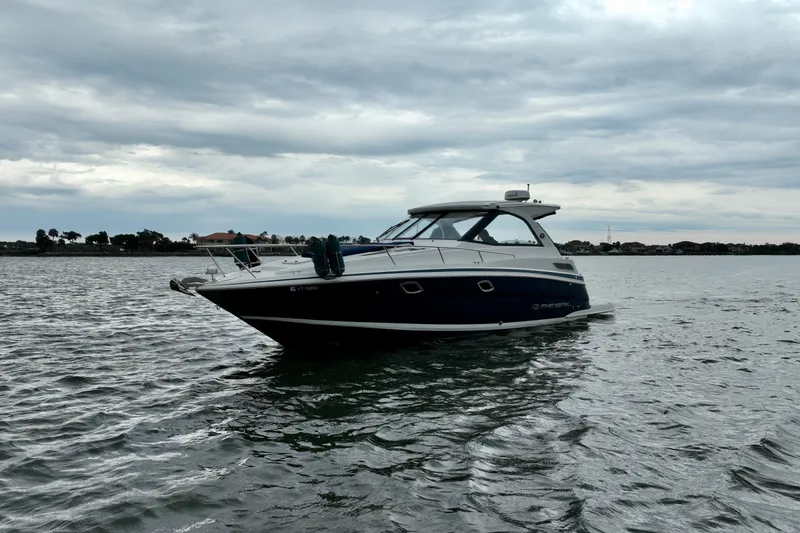 Slide: The Image of 2017 Regal 35 Sport Coupe boat on calm water under cloudy sky. - 11