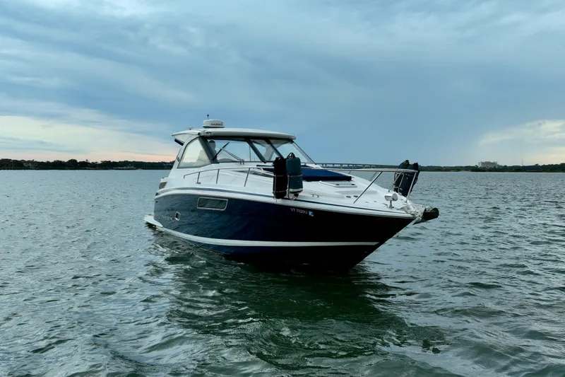 Slide: The Image of 2017 Regal 35 Sport Coupe boat on calm water under cloudy sky. - 12