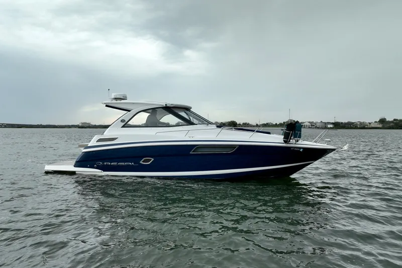 Slide: The Image of 2017 Regal 35 Sport Coupe boat on calm water under cloudy sky. - 14