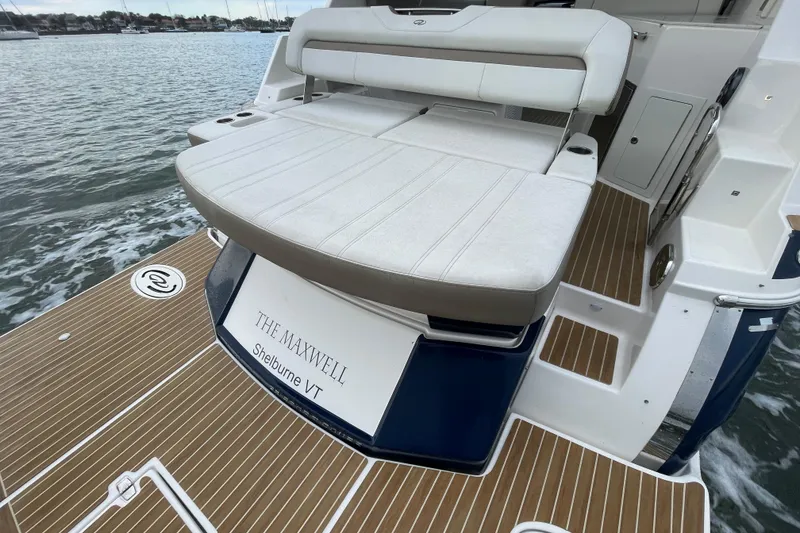 Slide: The Image of 2017 Regal 35 Sport Coupe boat with cushioned seating and wooden deck. - 16