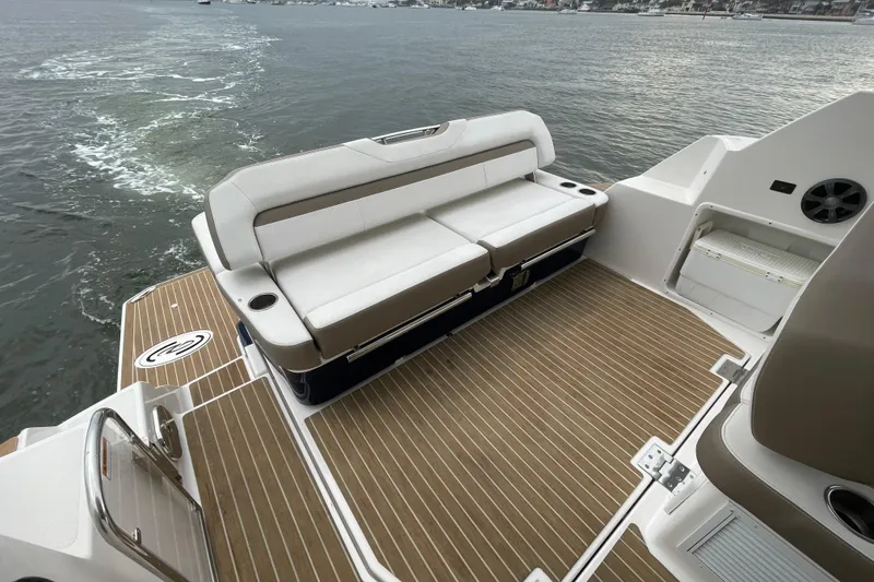 Slide: The Image of 2017 Regal 35 Sport Coupe boat deck with seating, overlooking calm waters. - 18
