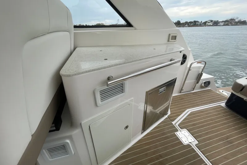 Slide: The Image of 2017 Regal 35 Sport Coupe interior with sleek countertop and wooden deck by the water. - 21