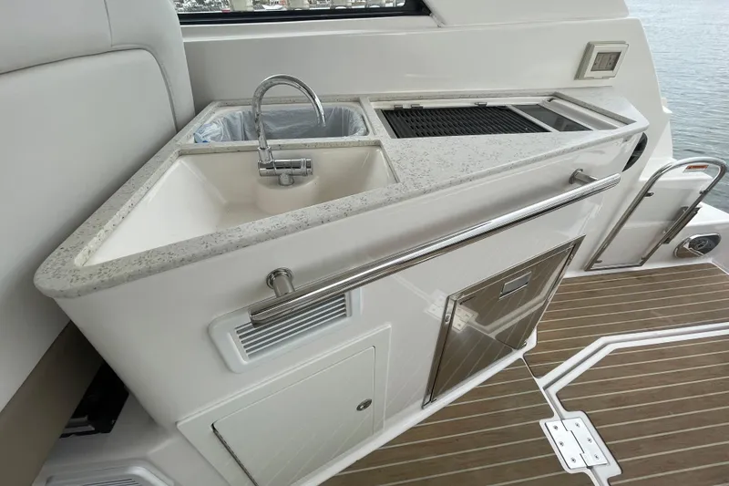 Slide: The Image of 2017 Regal 35 Sport Coupe yacht kitchenette with sink and grill on deck. - 22